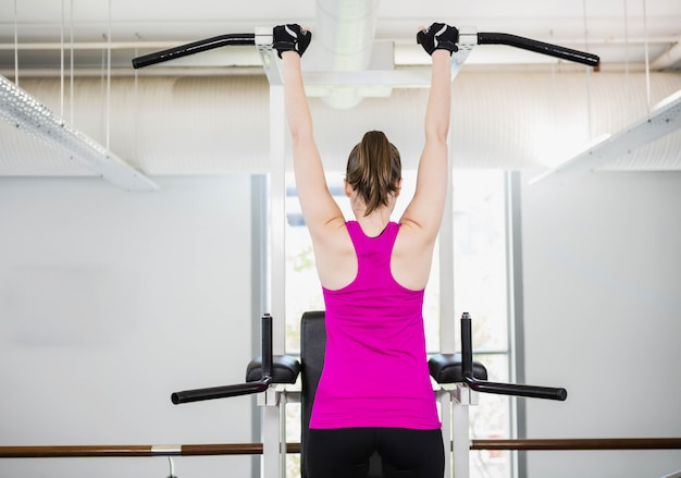 Fit femme faisant pull up à la gym