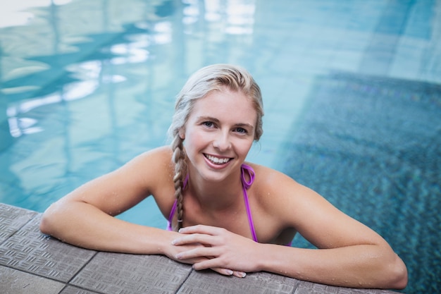 Fit femme reposant sur le bord de la piscine