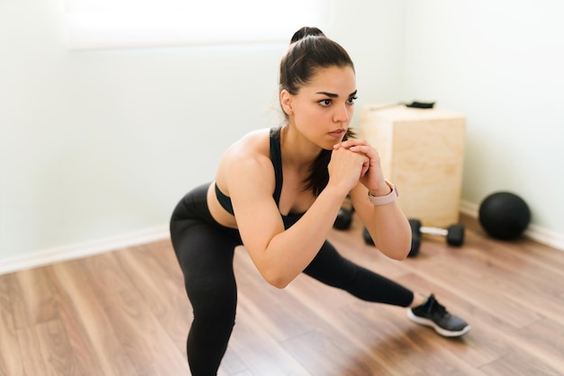 Fit femme s'entraînant à la maison pour avoir un corps mince et sain. Femme athlétique faisant de l'exercice avec un entraînement cardio