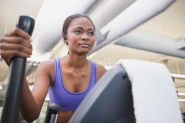 Fit femme travaillant sur le vélo elliptique