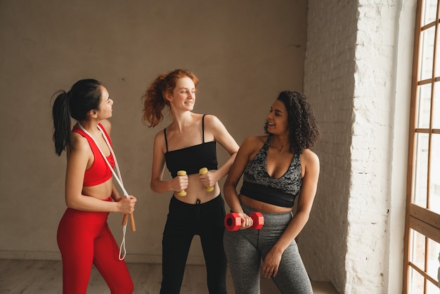 Fit les femmes sportives heureuses d'un mode de vie sain. Entraînement de fitness intense dans la salle de gym industrielle loft.