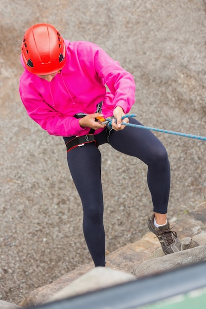 Fit fille en rappel sur le visage de la roche