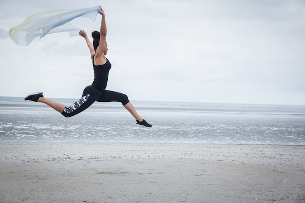 Fit fille sautant avec écharpe