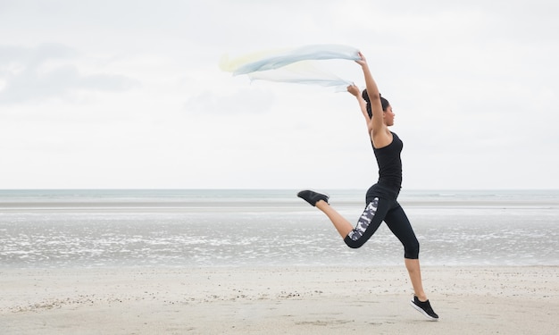 Fit fille sautant avec écharpe