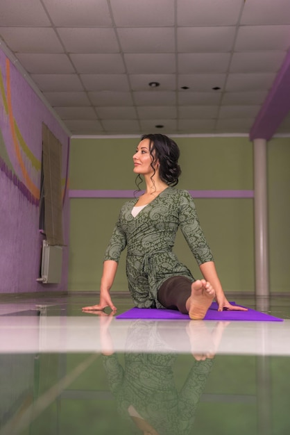 Fit girl démontrant des asanas de yoga dans un studio