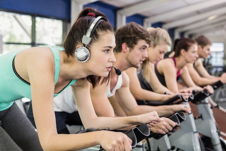 Photo fit groupe de personnes qui utilisent un vélo d'exercice dans la salle de gym