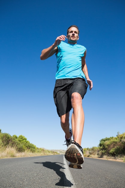 Fit homme faire du jogging sur la route