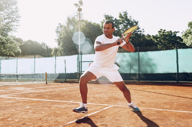 Fit homme joue au tennis sur un terrain de tennis