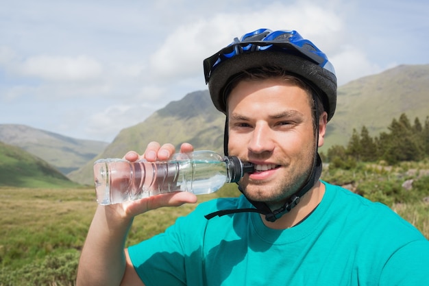 Fit l&#39;homme portant l&#39;eau potable de casque de vélo