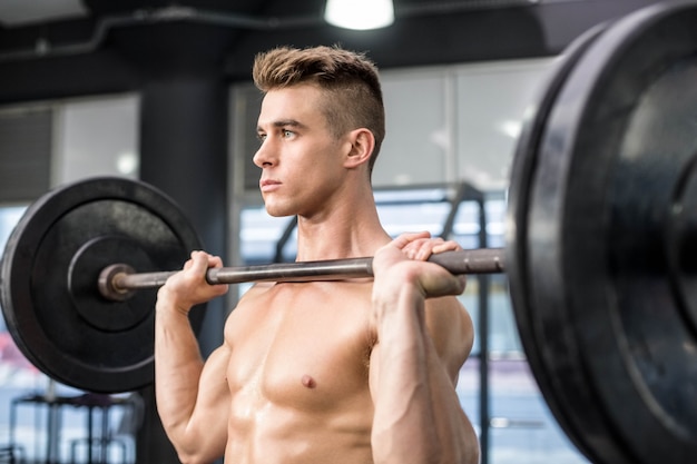 Fit homme soulevant des haltères au gymnase