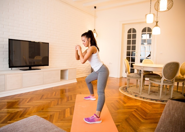 Fit jeune femme exsercise dans la chambre