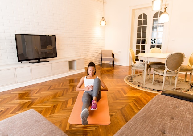 Fit jeune femme exsercise dans la chambre