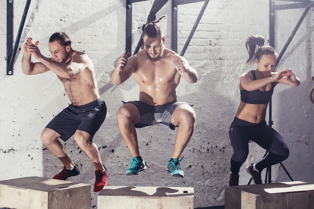 Fit les jeunes faisant des sauts en groupe dans un gymnase