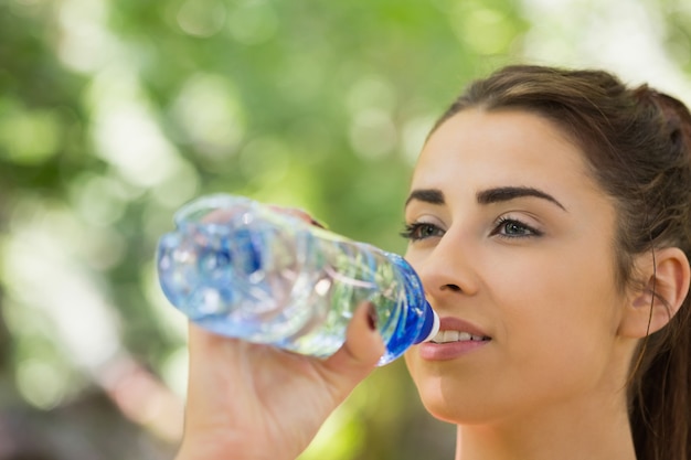 Fit jolie femme buvant à la bouteille de sport