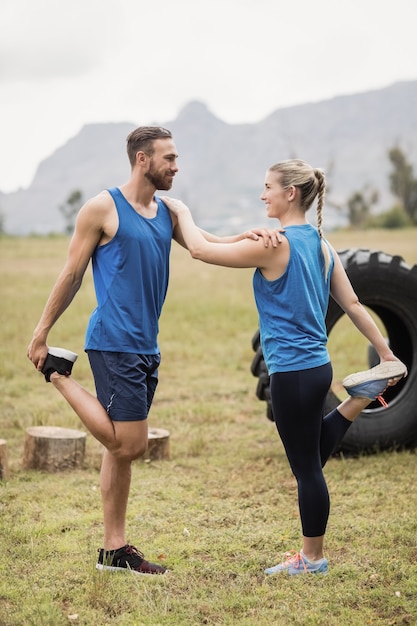 Fit personnes effectuant des exercices d'étirement dans le camp d'entraînement