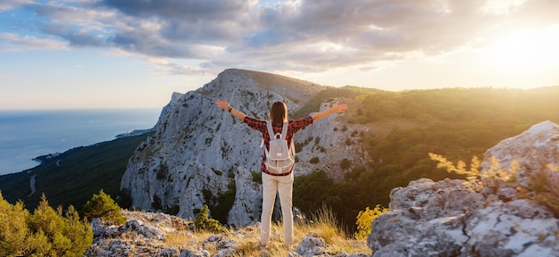 Fit randonneuse avec sac à dos debout sur une crête de montagne rocheuse