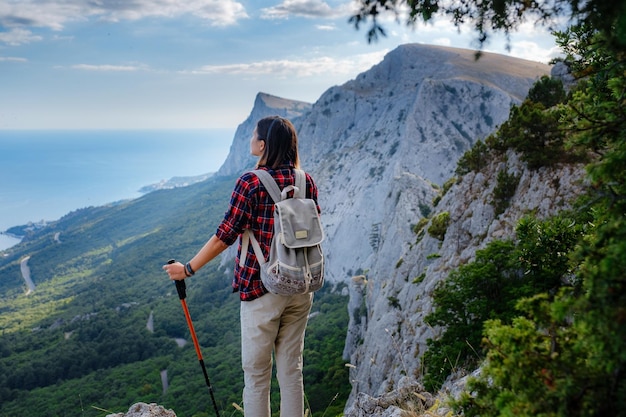 Fit randonneuse avec sac à dos debout sur une crête de montagne rocheuse