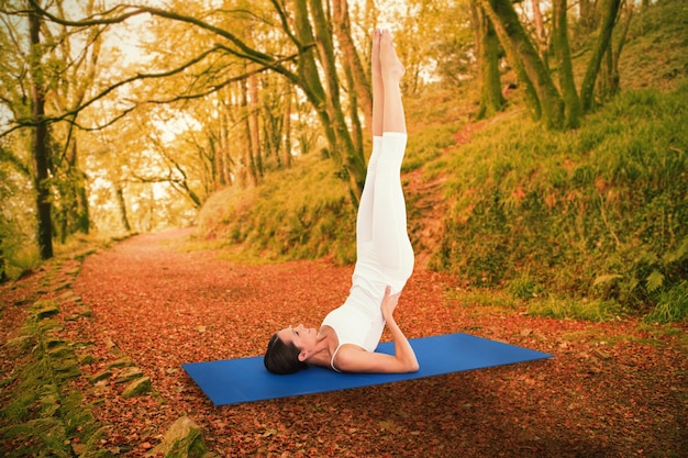 Fit woman stretching body in fitness studio contre paisible scène d'automne en forêt