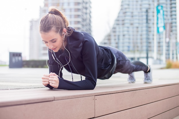 Fit youn femme faisant des exercices de planche en plein air