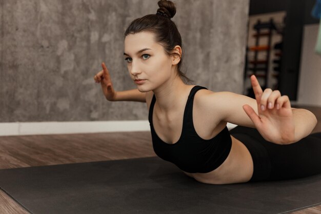 Fit young woman in sportswear faisant des exercices d'étirement des épaules et des bras