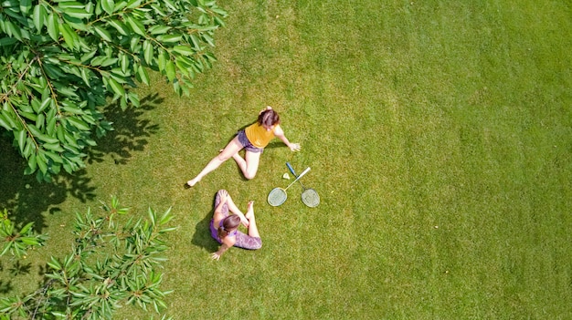 Fitness familial et sport à l'extérieur, adolescent mère et fille actif jouant au badminton dans le parc, vue de dessus aérienne