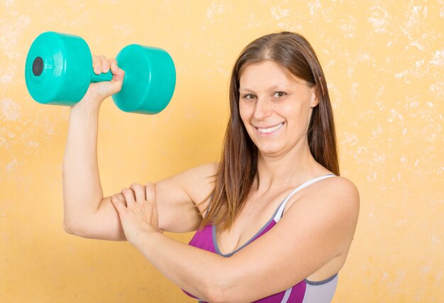 Fitness femme fait des poids pour les bras à la maison