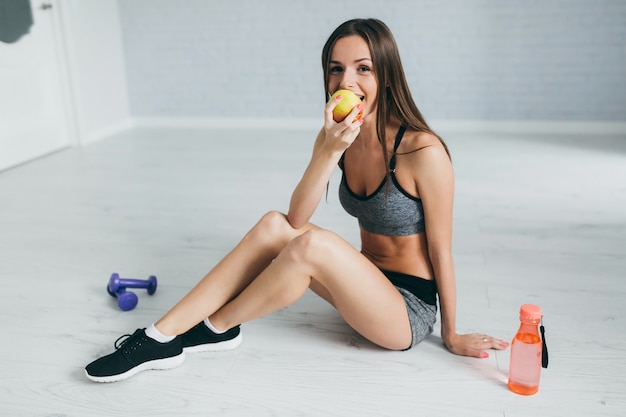 Fitness girl drinking watter et manger sainement