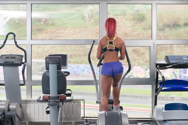 Fitness Girl exerçant sur le tapis roulant Moonwalker dans un centre de remise en forme moderne