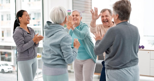 Fitness mains ensemble et personnes âgées pour l'exercice soutien célébration et travail d'équipe dans la classe d'exercice objectif d'entraînement d'exercice et groupe d'hommes et de femmes âgés avec cinq pour le succès de la santé