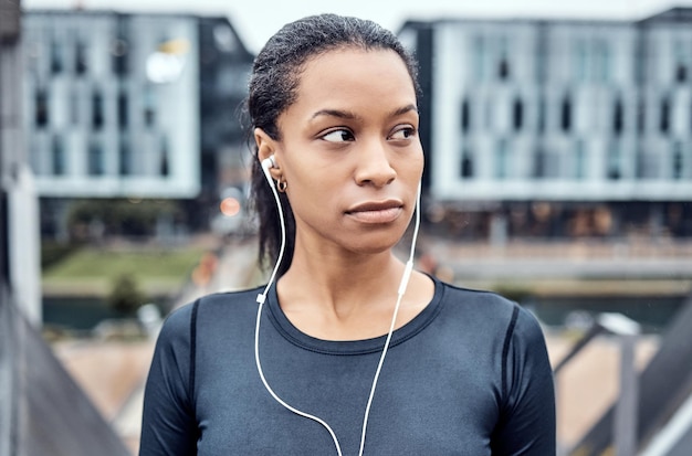 Fitness musical et visage de femme noire en ville pour le bien-être corps sain et entraînement cardio en ville urbaine Pensée sportive et fille écoutant de l'audio pour l'exercice de course et l'entraînement au marathon