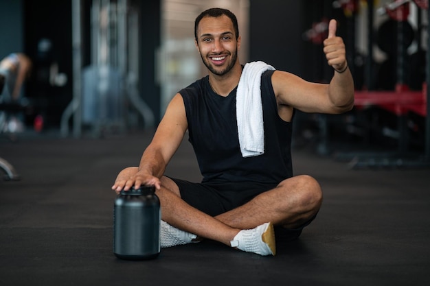 Fitness Nutrition Athlète masculin afro-américain souriant recommandant la poudre de protéine de lactosérum