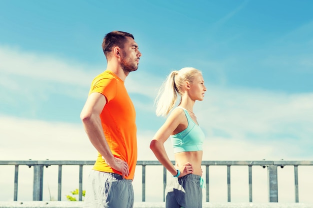 fitness, sport, amitié et concept de mode de vie sain - couple sportif à l'extérieur