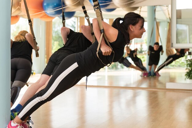 Fitness Trx Sangles de suspension Exercices d'entraînement Femmes et hommes travaillant avec leur propre Weith au gymnase