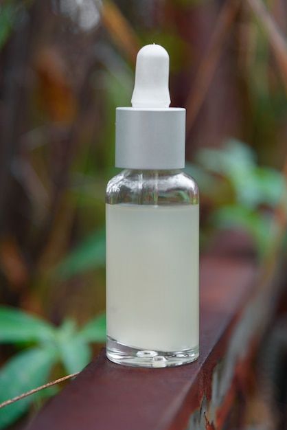 Photo flacon compte-gouttes en verre pour huile cosmétique ou sérum sur l'écorce d'un arbre