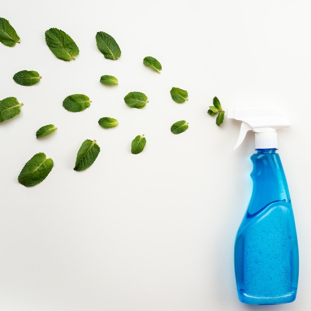 Flacon détergent bleu avec capuchon blanc vaporiser une feuille de menthe fraîche