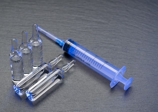 Flacon médical et ampoules pour injection et seringue sur le tableau gris avec copie espace