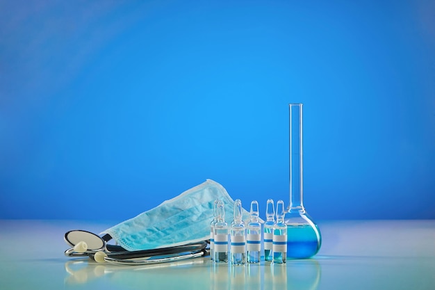 Flacon médical avec réactif chimique six ampoules avec masque liquide transparent et phonendoscope bleu