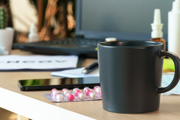 Flacon de médicament sur une table de bureau avec ordinateur portable se bouchent