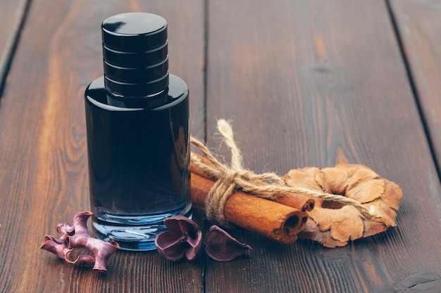 Flacon noir de parfum posé sur une table en bois