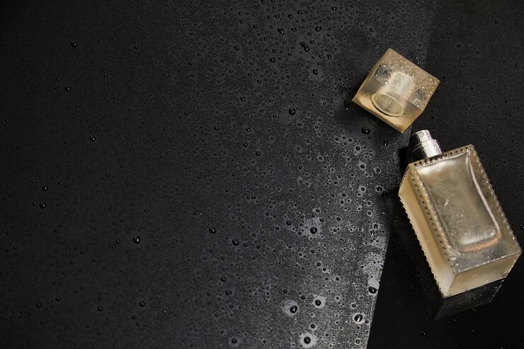 Photo flacon de parfum cosmétique en verre transparent sur le fond sombre avec des gouttes d'eau