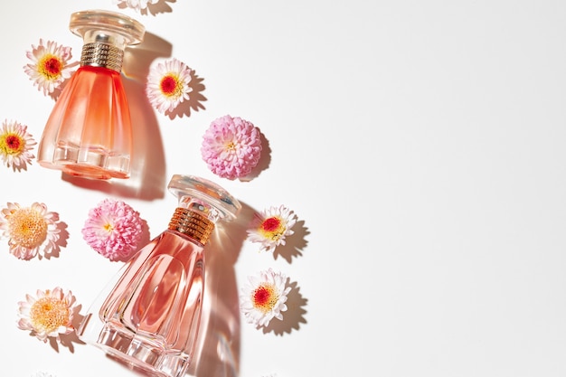 Flacon de parfum entouré de boutons floraux close up