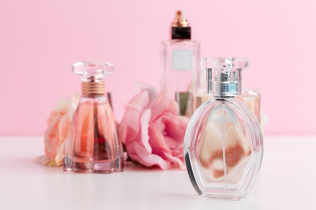 Flacon de parfum avec des fleurs sur la couleur