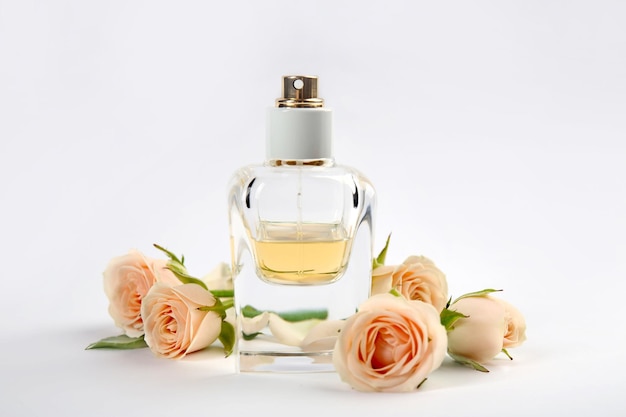 Flacon de parfum avec des fleurs sur fond clair