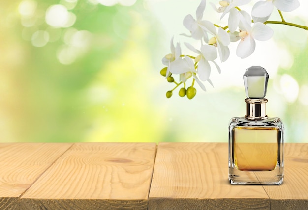 Flacon de parfum et fleurs sur fond.