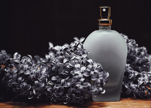 Flacon de parfum avec fleurs lilas