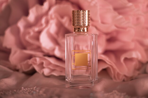 Flacon de parfum avec des fleurs sur la surface de couleur