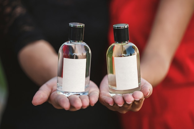 Flacon De Parfum D'une Main Féminine. Jeune Femme élégante Tenant Une Bouteille De Parfum. Parfum à La Mode Dans Les Mains Des Femmes. Fille De Pulvérisation De Parfum. Belles Mains Féminines. Parfums Pour Femmes