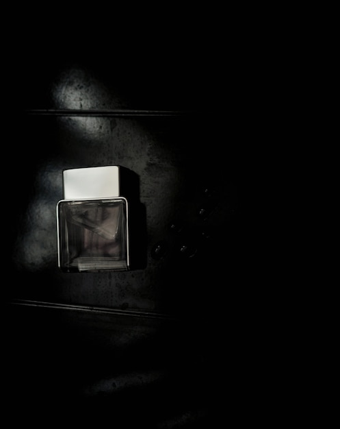 Photo flacon de parfum. maquette sur fond grungy sombre ou noir. parfum pour homme. vue de dessus.