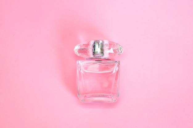 flacon de parfum pulvérisé sur fond pastel rose