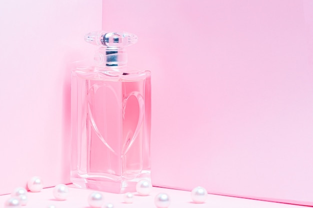 Flacon de parfum rose avec des perles